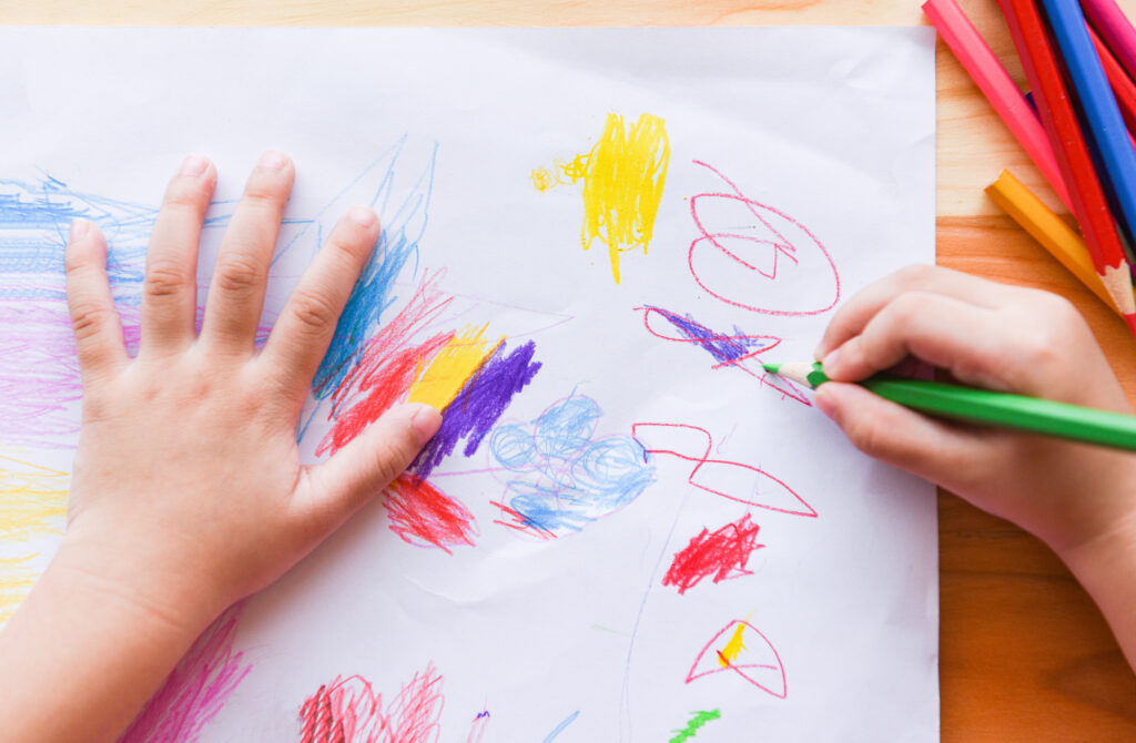 Child's hands with colourful scribbles